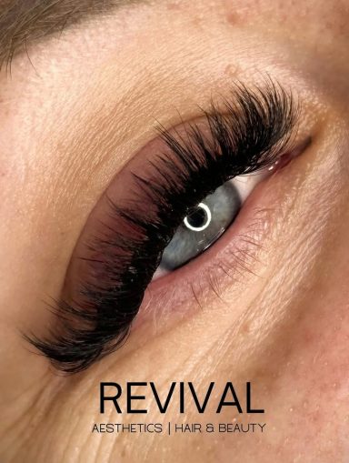 Close-up of an eye with bold eyelashes, showcasing vibrant blue iris and natural details.